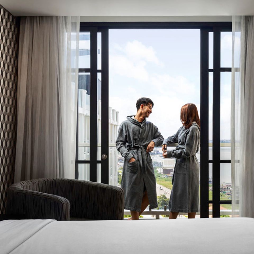 a couple relaxing on the balcony wearing grey robes